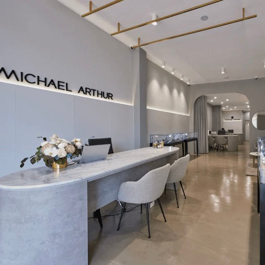 Modern interior design with a reception desk and chairs, featuring the brand 'Michael Arthur'.